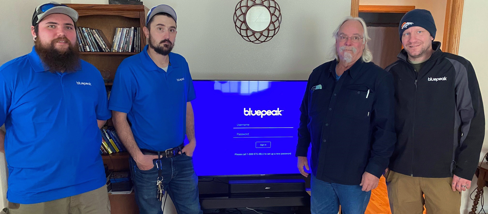 Bluepeak’s Derreck Easley, Christian Hauf and Wesley Foster (left to right) stand with Gary Powell, the fiber internet provider’s first customer in Sheridan, Wyo.