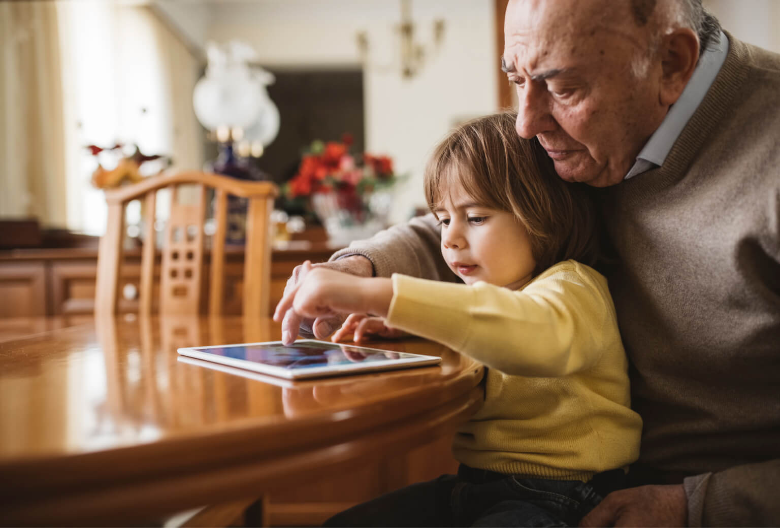 Grandpa and Grandaughter using a tablet device together